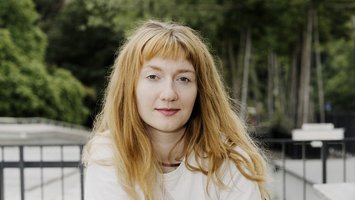 junge Frau mit weißem Shirt im Freien, lange blonde Haare