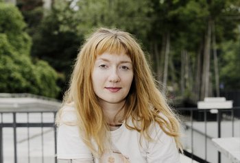 junge Frau mit weißem Shirt im Freien, lange blonde Haare